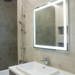 Bathroom interior with mirror and wash basin.